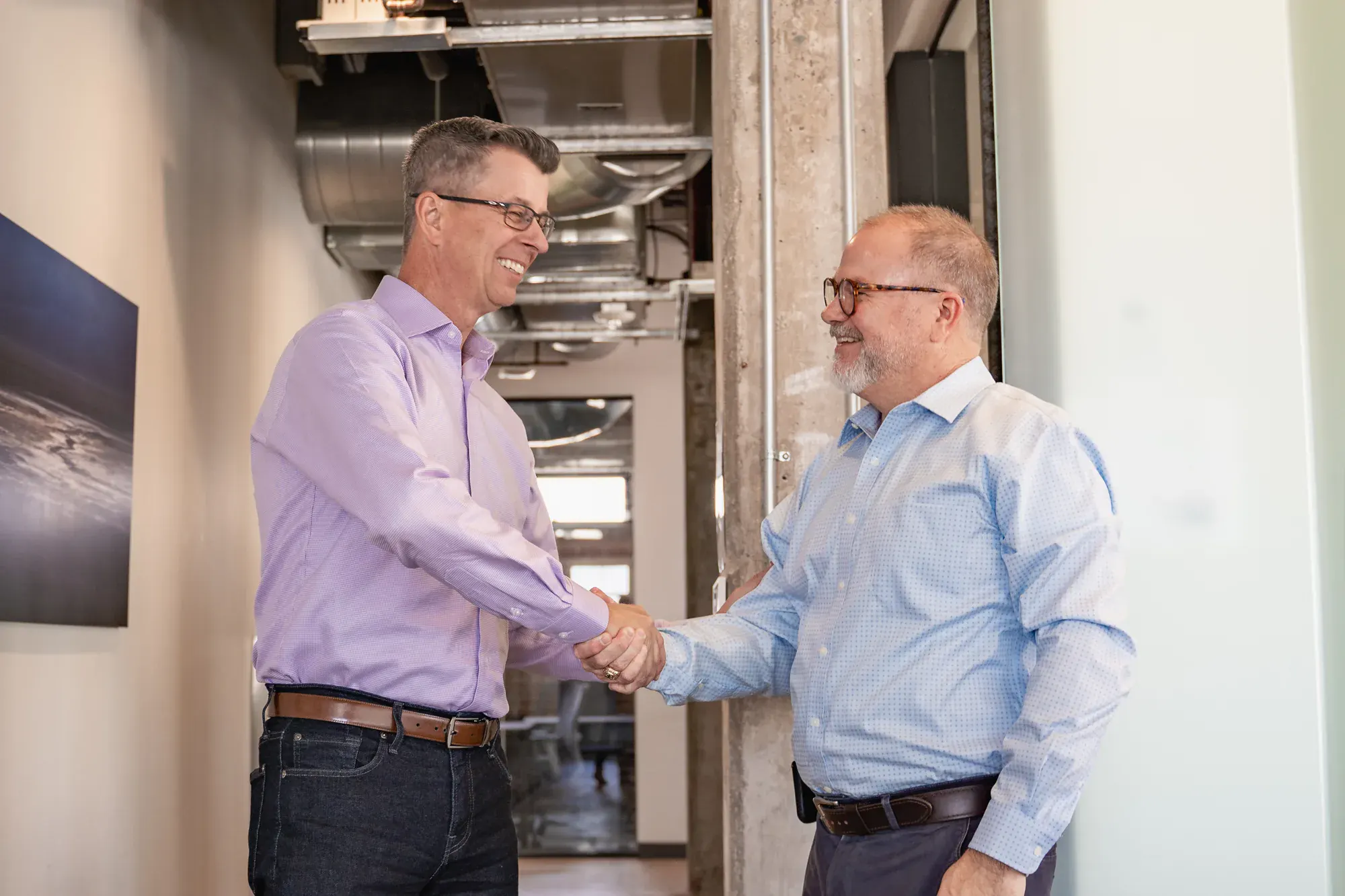 A StrongerWork founder shaking hands with a client in the office