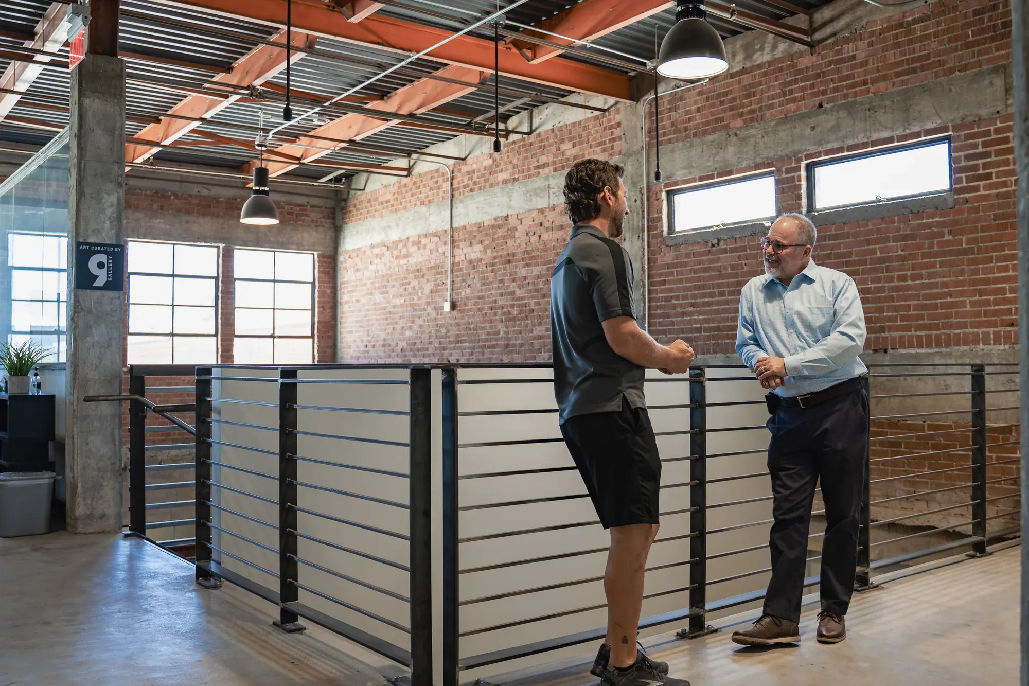 Two colleagues in conversation on an open mezzanine